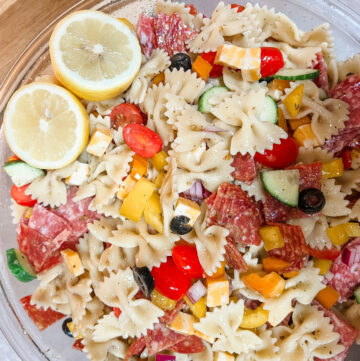 Cold pasta salad with lots of vegetables lemon cut in half