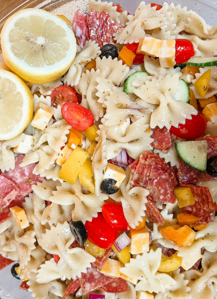 Cold pasta salad with lots of vegetables lemon cut in half