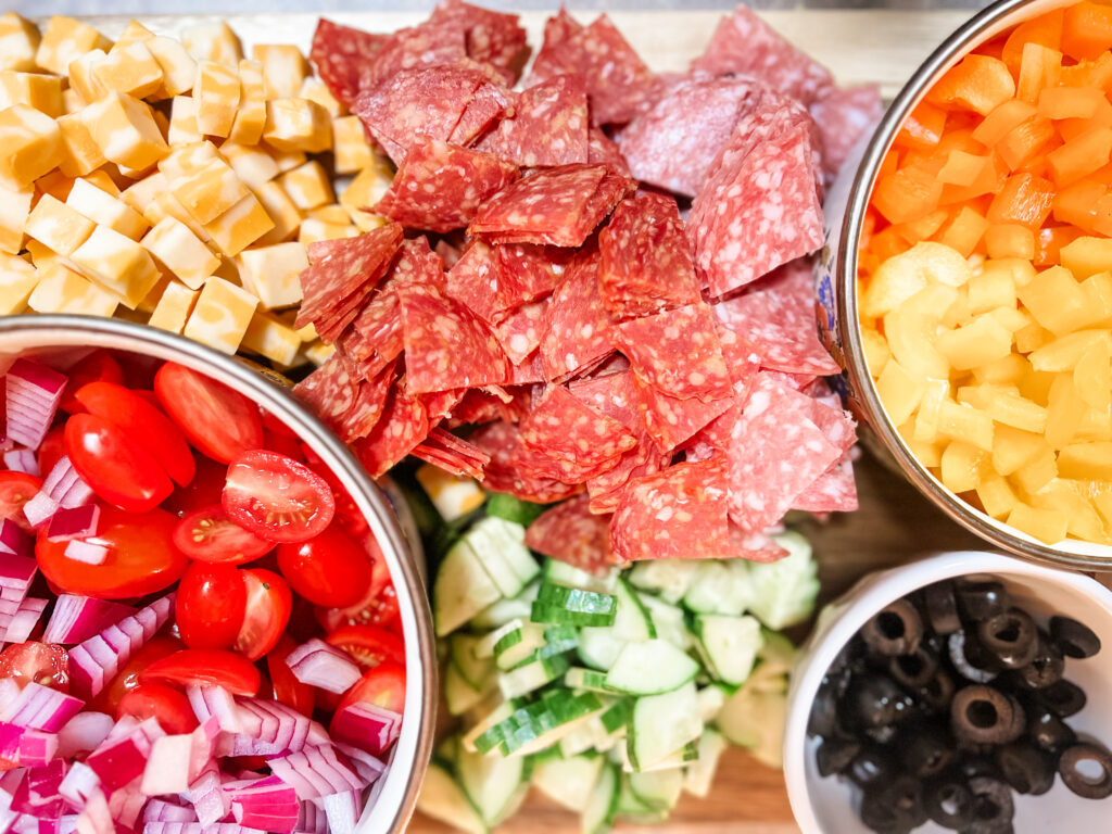 Pasta Salad ingredients Pepperoni, salame, tomatoes, onions, cheese, cucumbers, bell peppers, olives chopped up